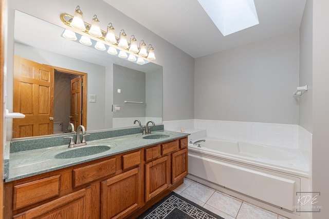 full bathroom featuring a skylight, a sink, a bath, and tile patterned floors