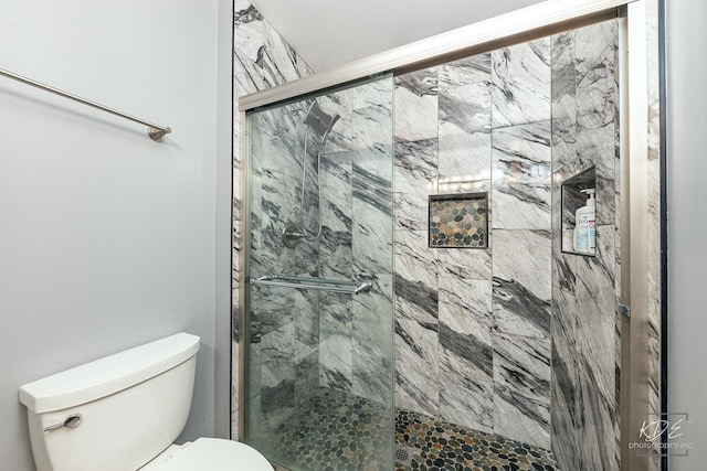 full bath featuring toilet and a marble finish shower