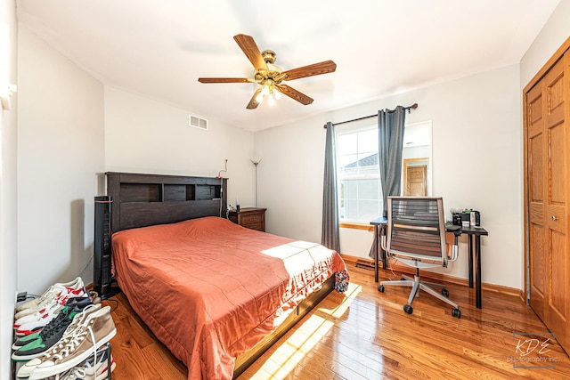 bedroom with a ceiling fan, light wood-type flooring, visible vents, and baseboards