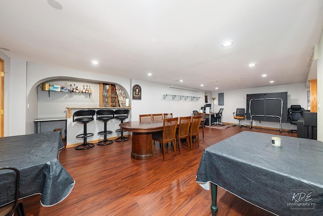 rec room featuring a bar, wood finished floors, and recessed lighting