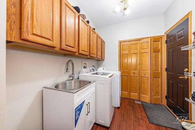 laundry area featuring dark wood finished floors, cabinet space, a sink, and separate washer and dryer