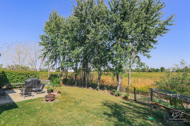 view of yard with an outdoor fire pit, fence, and a patio