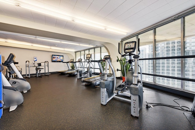 workout area with a wall of windows and a healthy amount of sunlight