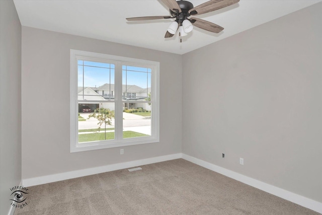 carpeted spare room with a wealth of natural light and ceiling fan