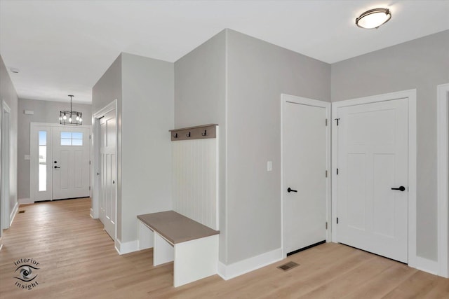 foyer with an inviting chandelier and light hardwood / wood-style flooring