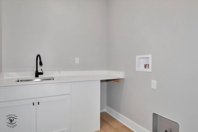 laundry area with cabinets, washer hookup, light wood-type flooring, and sink