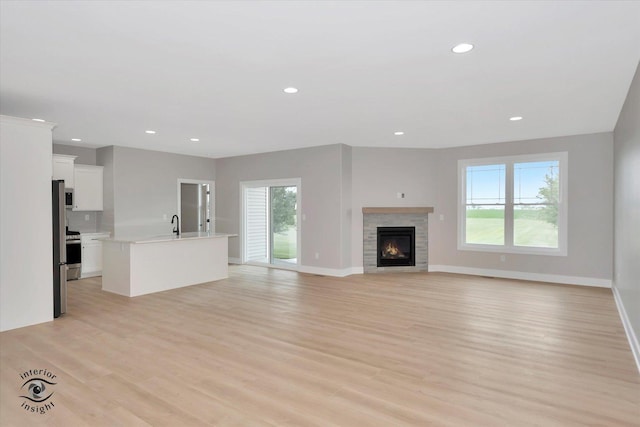 unfurnished living room featuring light hardwood / wood-style flooring and sink