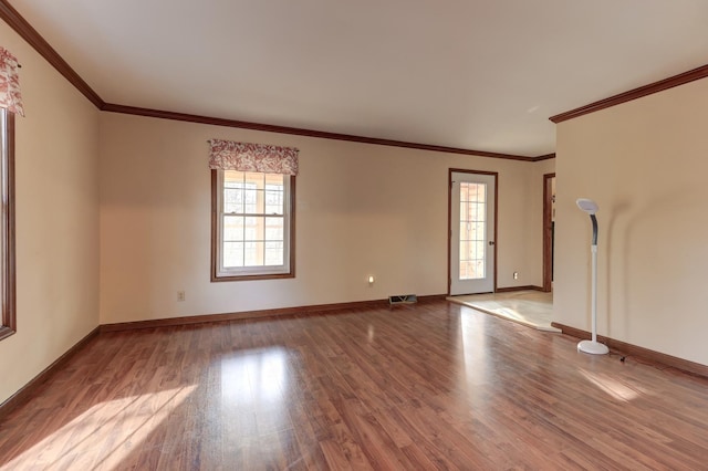 empty room with crown molding and light hardwood / wood-style flooring