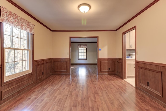 unfurnished room with light hardwood / wood-style floors and ornamental molding