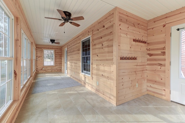 unfurnished sunroom with ceiling fan