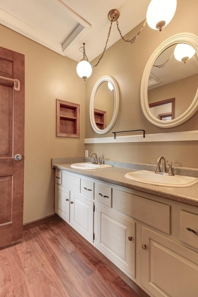 bathroom with hardwood / wood-style floors, vanity, and ornamental molding