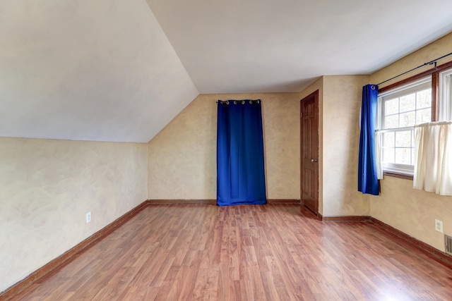 bonus room featuring hardwood / wood-style flooring and vaulted ceiling