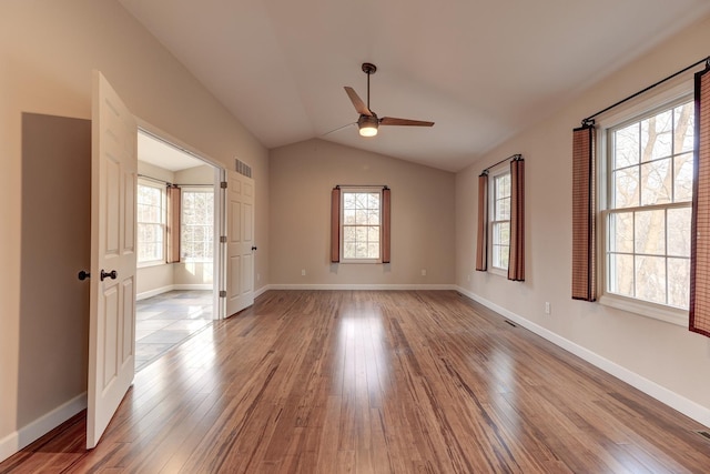 unfurnished room featuring a healthy amount of sunlight, ceiling fan, light hardwood / wood-style floors, and lofted ceiling