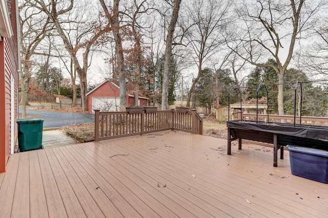 wooden terrace featuring a garage and an outbuilding