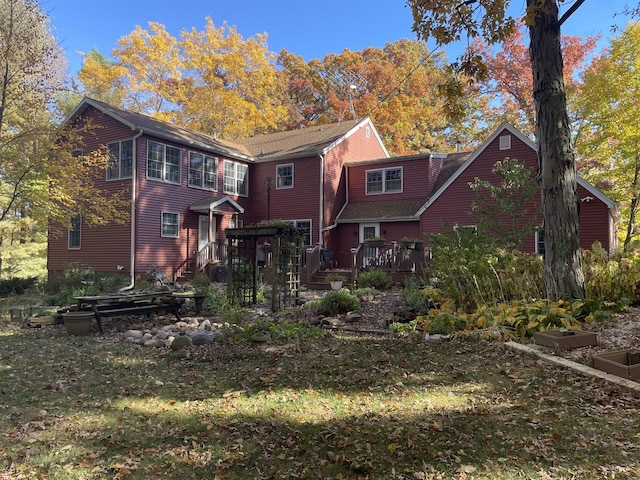 rear view of house with a lawn and a deck