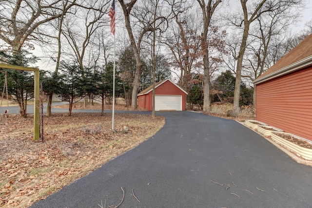 view of yard featuring a garage and an outbuilding