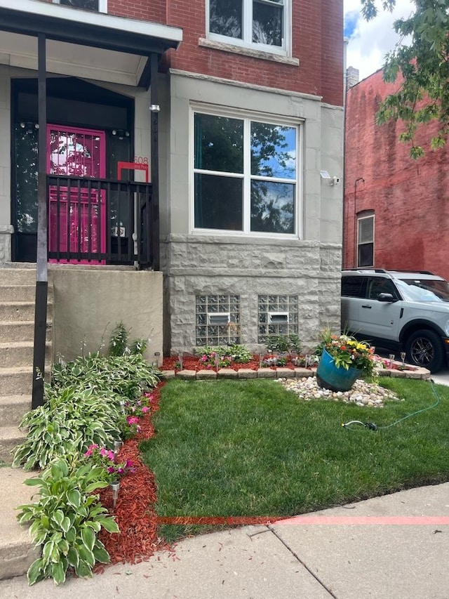 view of exterior entry featuring a yard