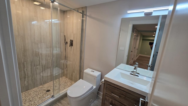 bathroom with vanity, toilet, and a shower with door