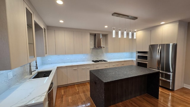 kitchen with a center island, backsplash, wall chimney exhaust hood, light hardwood / wood-style floors, and stainless steel appliances