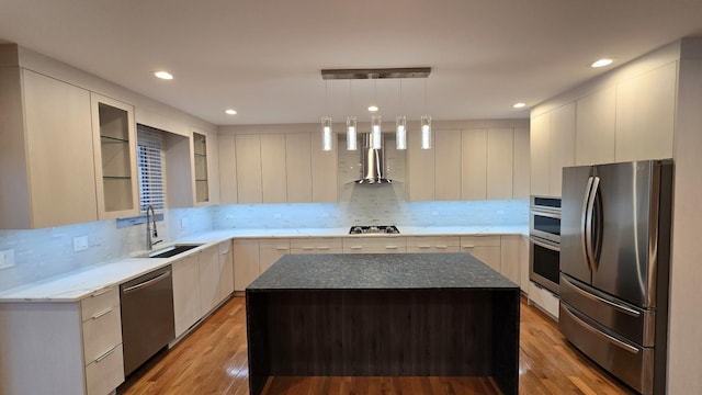 kitchen featuring decorative backsplash, a center island, wall chimney exhaust hood, and appliances with stainless steel finishes