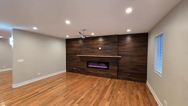 unfurnished living room featuring ceiling fan and light hardwood / wood-style flooring