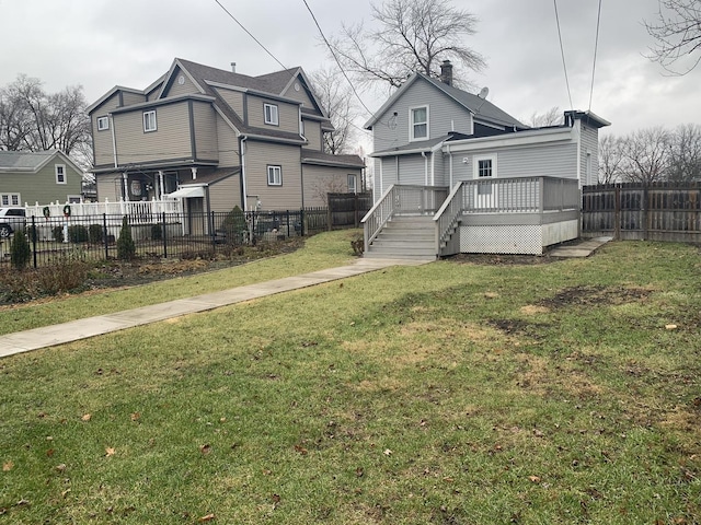 back of house featuring a wooden deck and a yard