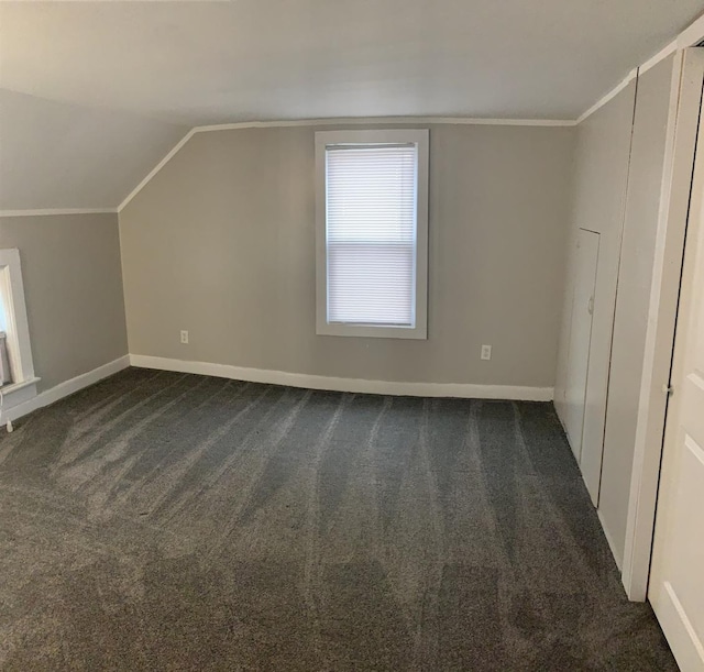 bonus room with dark carpet and lofted ceiling