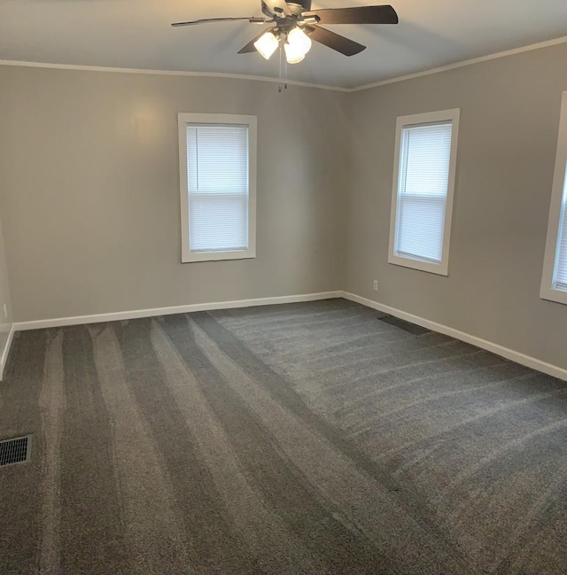 unfurnished room with dark colored carpet, ceiling fan, and crown molding