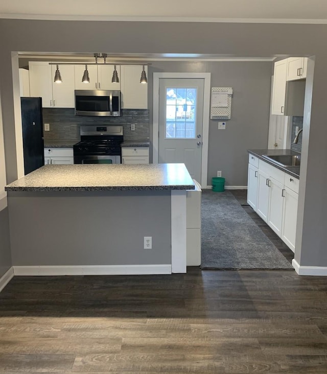 kitchen featuring sink, dark hardwood / wood-style flooring, backsplash, white cabinets, and appliances with stainless steel finishes