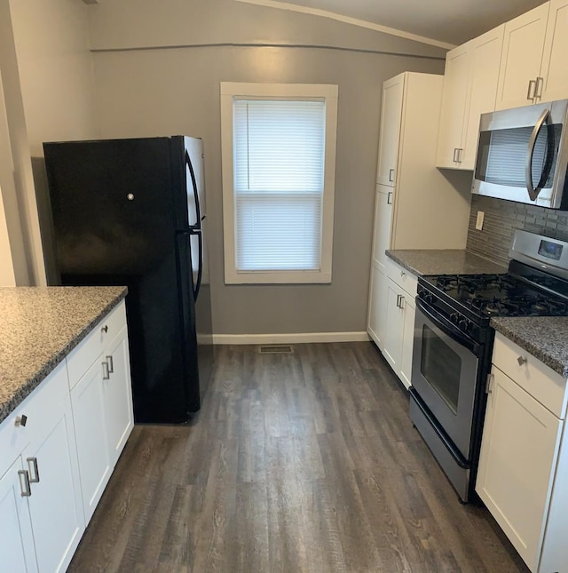 kitchen with dark hardwood / wood-style flooring, backsplash, dark stone counters, stainless steel appliances, and white cabinetry