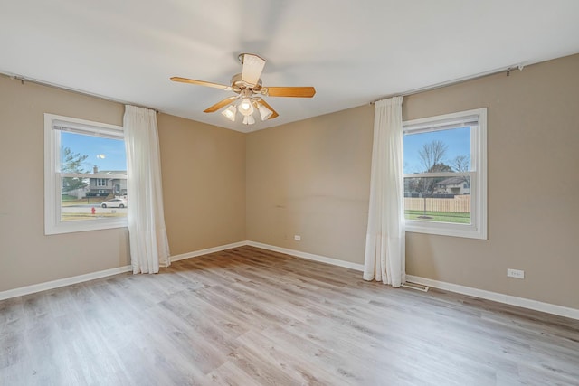 empty room with ceiling fan, light hardwood / wood-style flooring, and plenty of natural light