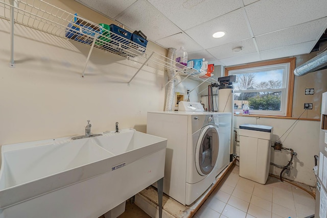 laundry area featuring tile patterned floors, sink, and washing machine and clothes dryer