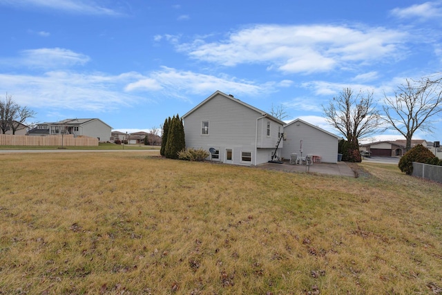 back of property with a yard and a patio