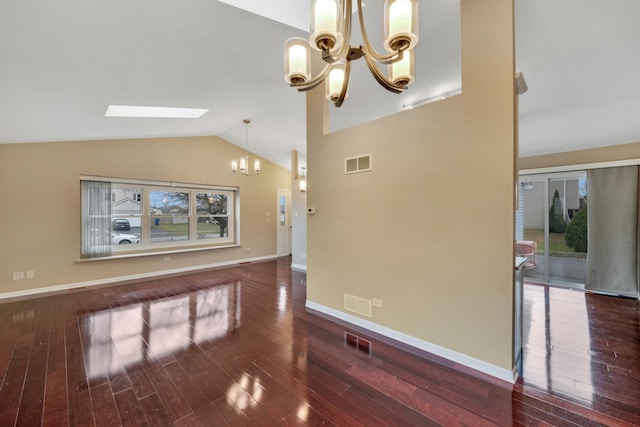 unfurnished living room with lofted ceiling with skylight, dark wood-type flooring, and a chandelier