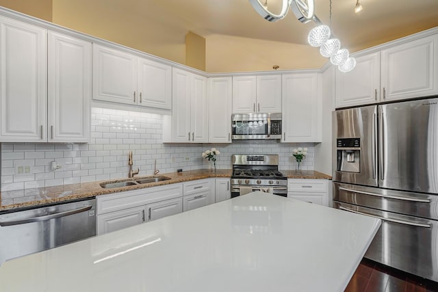 kitchen with white cabinets, sink, backsplash, and appliances with stainless steel finishes