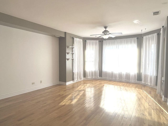 empty room with hardwood / wood-style flooring and ceiling fan