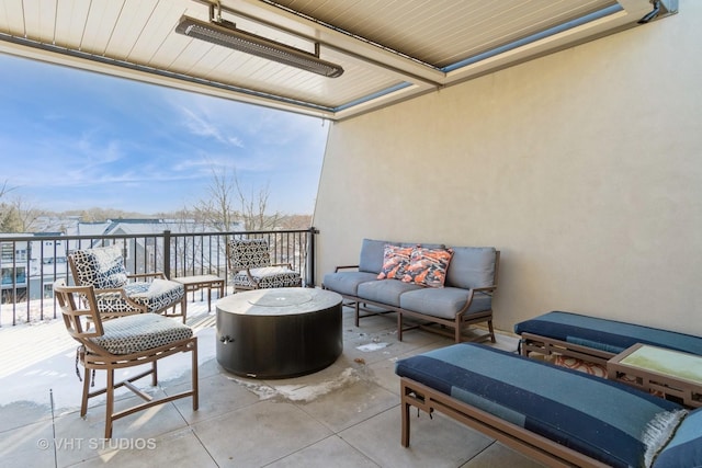 snow covered patio with a balcony and outdoor lounge area