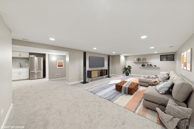 living room featuring light carpet and sink