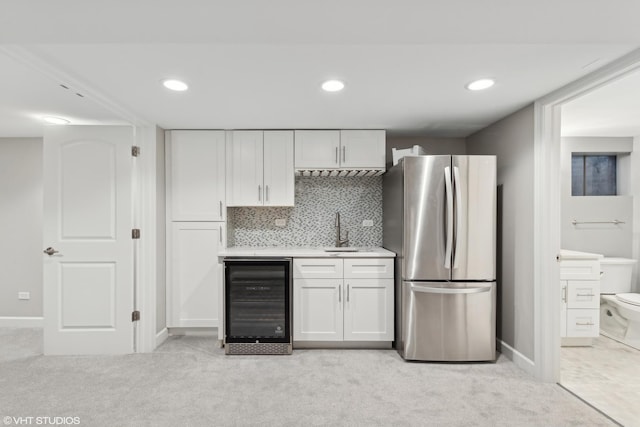 kitchen with white cabinets, sink, decorative backsplash, stainless steel fridge, and beverage cooler