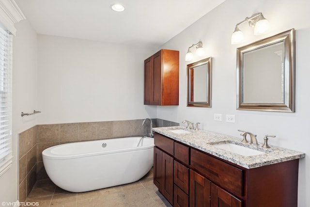 bathroom with tile patterned flooring, vanity, and a tub to relax in