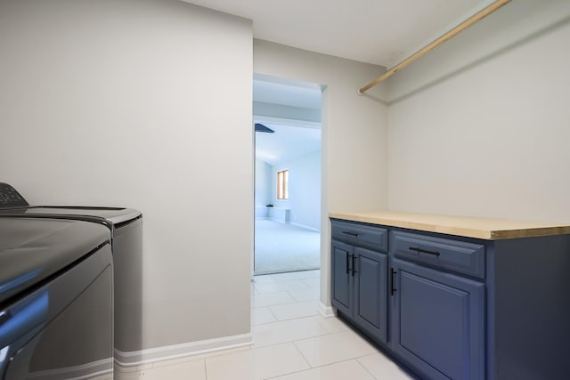 laundry room featuring cabinets, light tile patterned floors, and washing machine and dryer