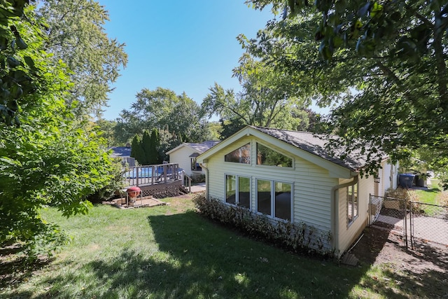 back of property featuring a deck and a lawn