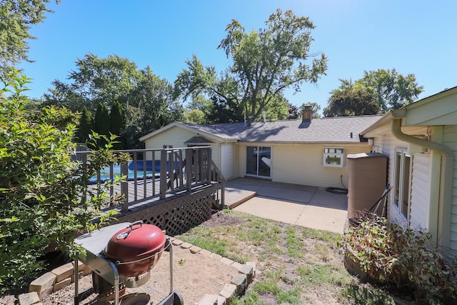 back of property with a swimming pool side deck and a patio