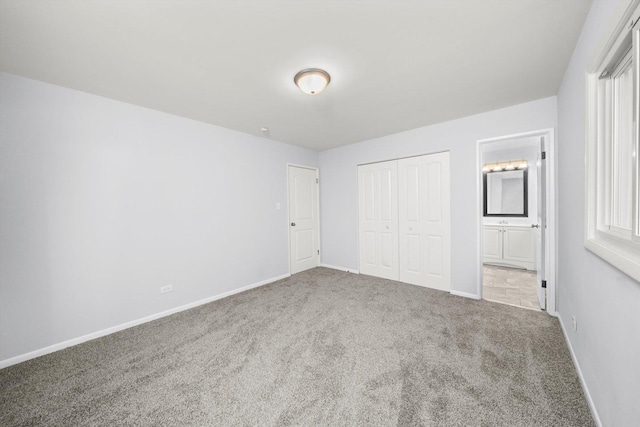 unfurnished bedroom with connected bathroom, a closet, and carpet floors