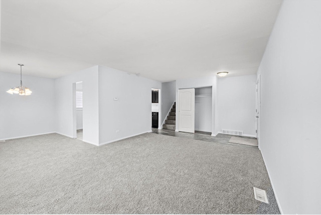 unfurnished room featuring carpet floors and a chandelier