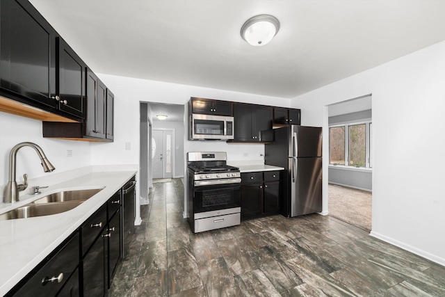 kitchen with dark colored carpet, sink, and appliances with stainless steel finishes