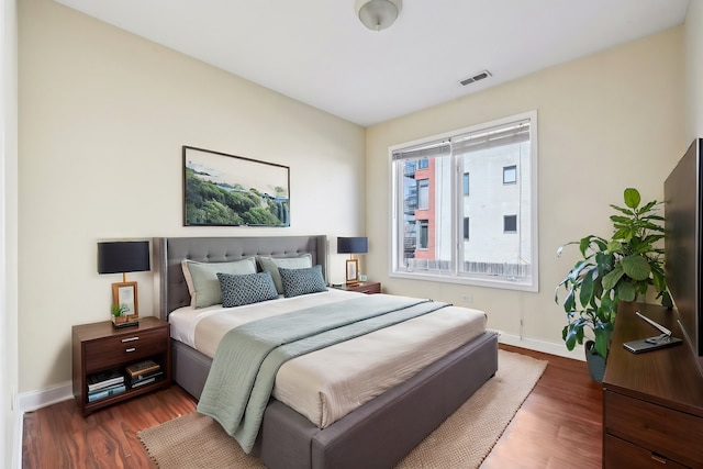 bedroom featuring dark wood-style flooring, visible vents, and baseboards