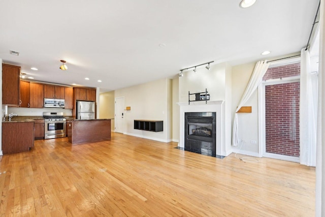 unfurnished living room featuring recessed lighting, a fireplace with flush hearth, visible vents, baseboards, and light wood finished floors