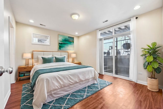 bedroom with access to exterior, baseboards, visible vents, and wood finished floors