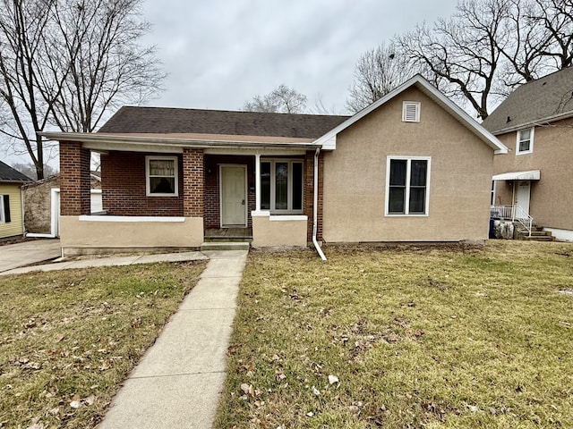 bungalow-style home with covered porch and a front lawn